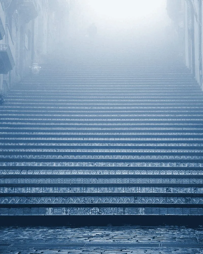 Stone staircase rising step by step into soft fog